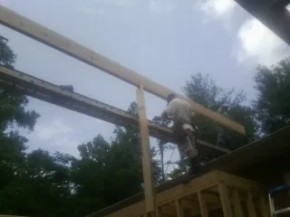 Carpenter setting a ridge beam over a new addition frame — Ice Dam Removal by Roofing Brothers in Paramus