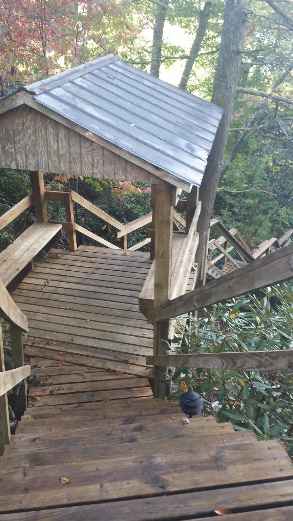Metal roofed shelter over wooden steps on a wooded walkway — Skylight Repair & Installation work by our crew in Paramus